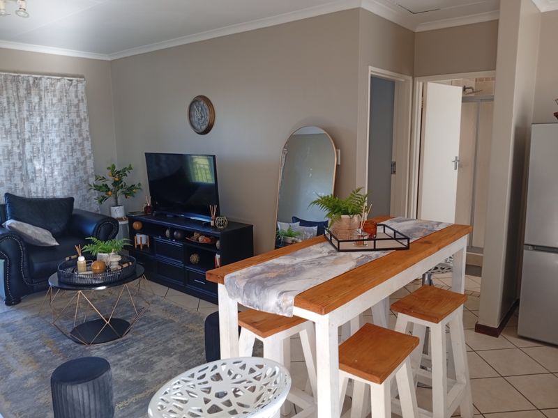 Open plan living and dining area featuring tiled flooring and neutral wall tones, providing a functional layout with direct access to adjacent rooms.