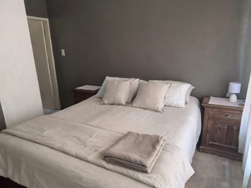 A neutrally decorated bedroom featuring dark accent walls and a simple layout, offering a comfortable and quiet sleeping space.