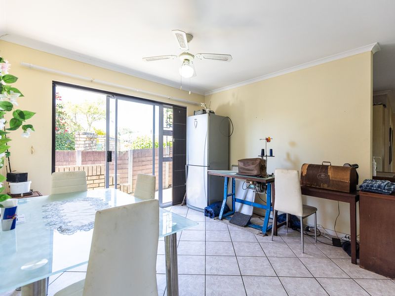 Dining area featuring tiled flooring, a ceiling fan, and a sliding glass door providing access to the outdoor space.