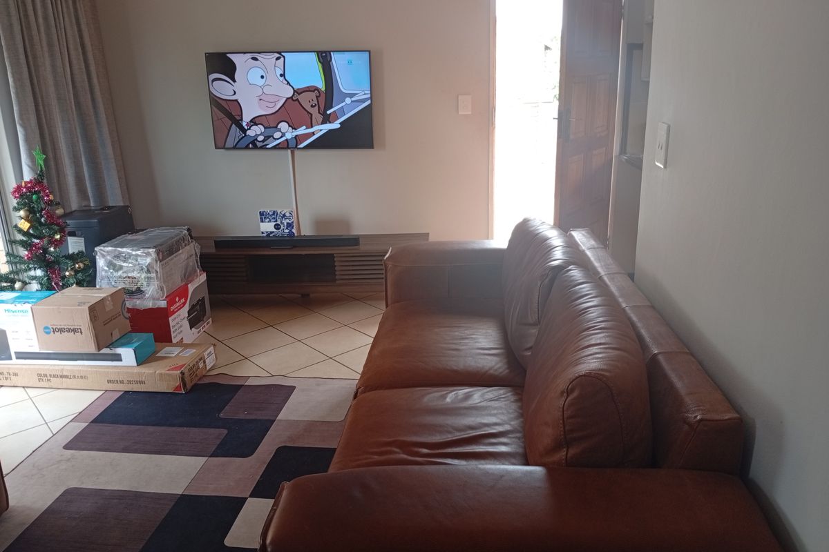 A living room area featuring tiled flooring and direct access to an external door, providing a functional space for relaxation.