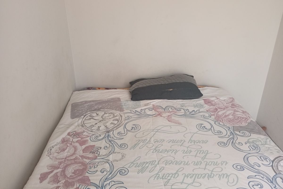 A compact bedroom space featuring neutral wall finishes, suitable for a single bed configuration.