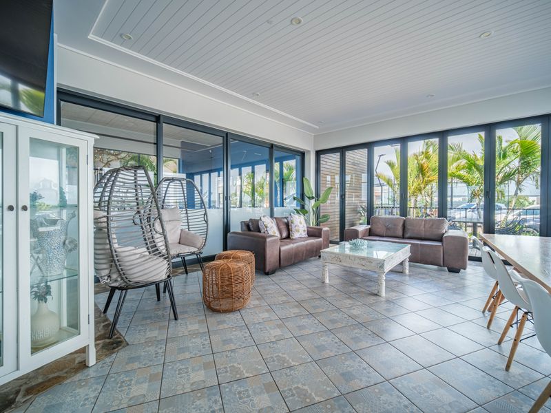 Spacious open-plan living area featuring decorative tiled flooring, recessed ceiling lighting, and expansive glass sliding doors that provide abundant natural light.