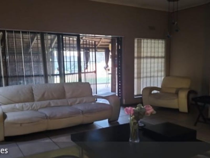 Spacious living room featuring tiled flooring and large sliding glass doors that provide access to the outdoor patio area.