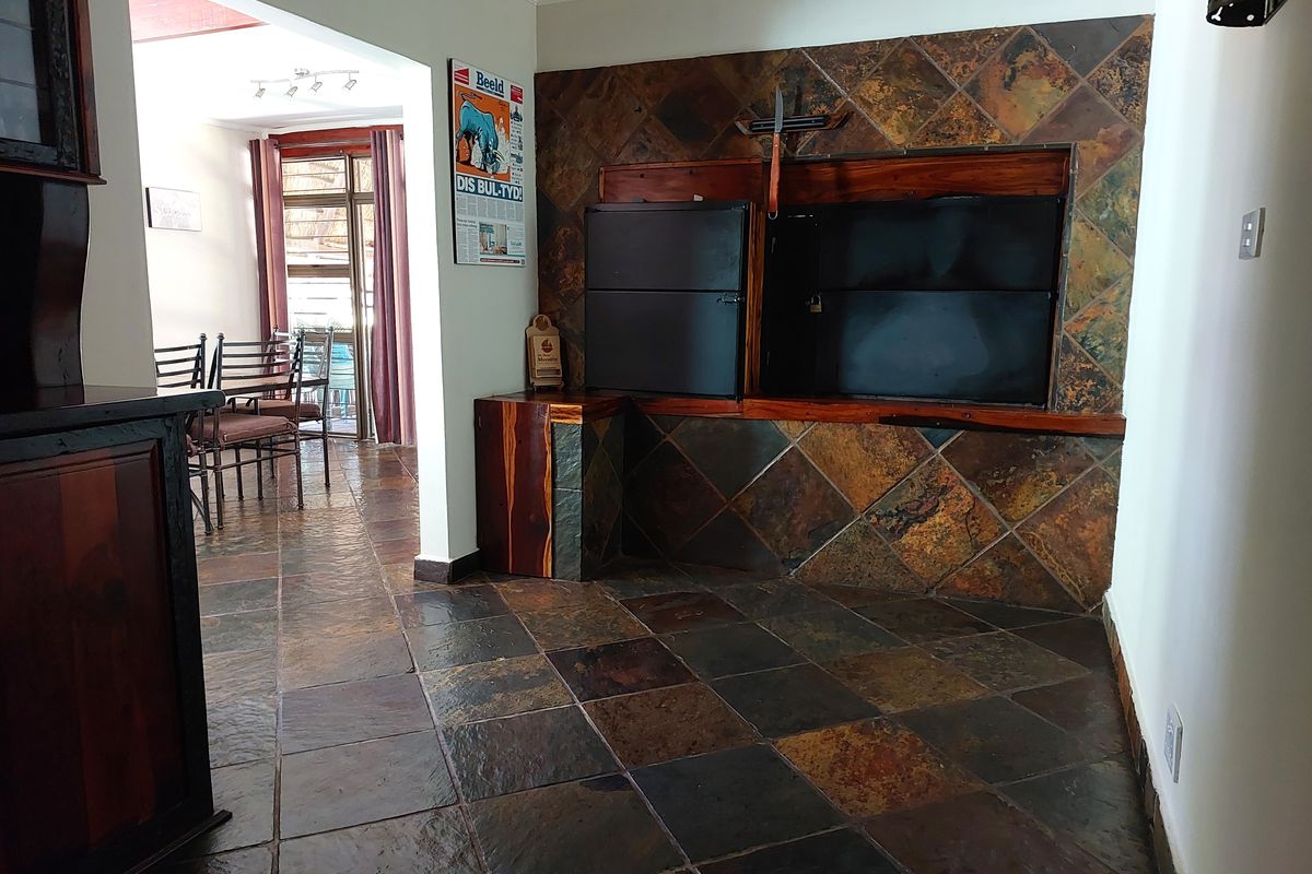 Living area featuring a built-in indoor braai with slate tile surround and matching slate flooring throughout the space.