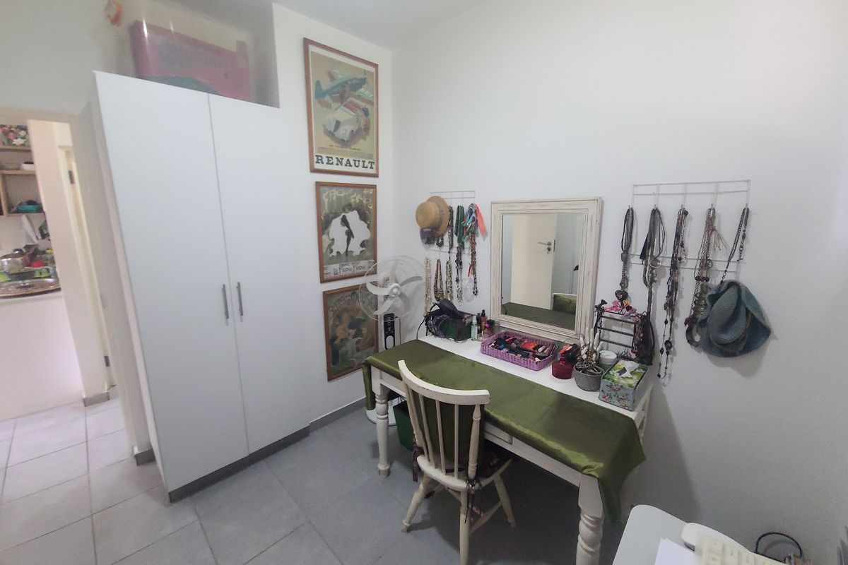 A bedroom featuring a built-in wardrobe and tiled flooring, offering a functional space with neutral finishes.