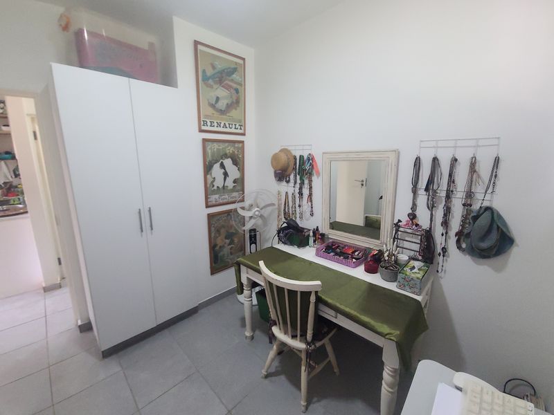 A bedroom featuring a built-in wardrobe and tiled flooring, offering a functional space with neutral finishes.