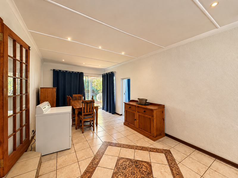 Open plan living and dining area featuring tiled flooring, recessed lighting, and direct access to the outdoor patio through a sliding glass door.