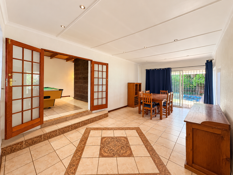 Spacious living area featuring tiled floors with decorative inlay, recessed lighting, and direct access to the garden through sliding glass doors.