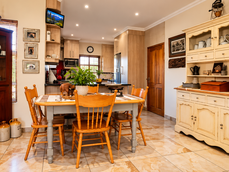 Spacious open-plan dining and kitchen area featuring tiled flooring, recessed lighting, and ample built-in cabinetry, creating a warm and functional living space.