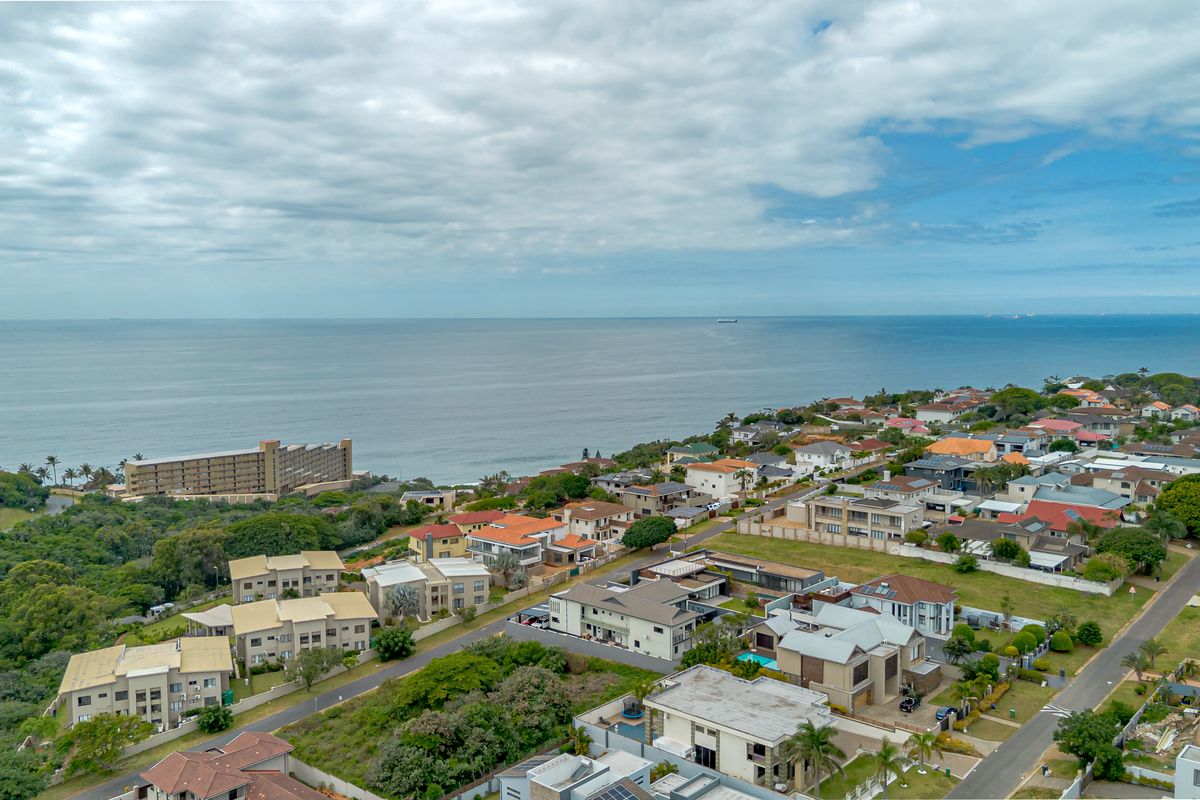 An aerial view of a coastal residential neighborhood, showcasing the proximity to the ocean and the surrounding suburban landscape.
