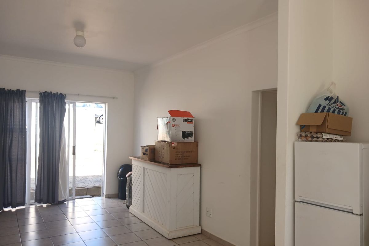 A living area featuring ceramic floor tiles and a sliding glass door providing access to the exterior.
