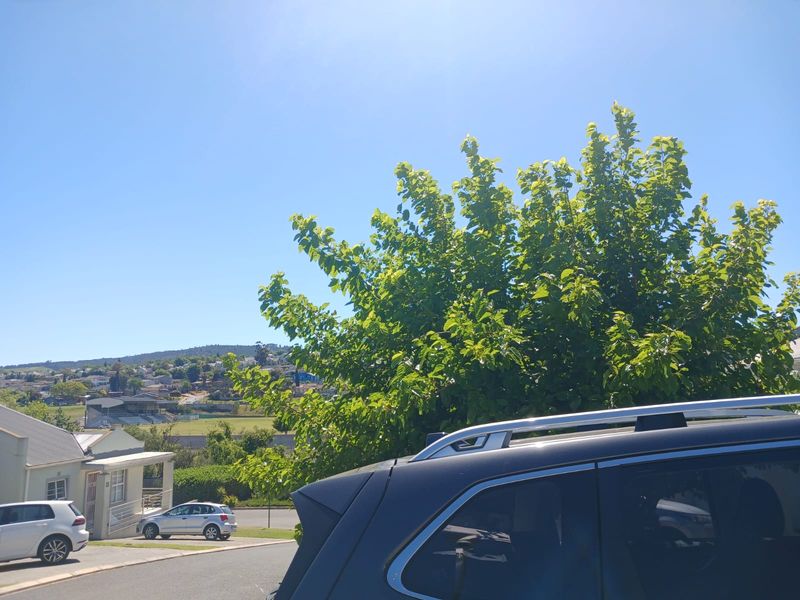 A street-level view of the neighbourhood showing surrounding residential properties and local landscape.
