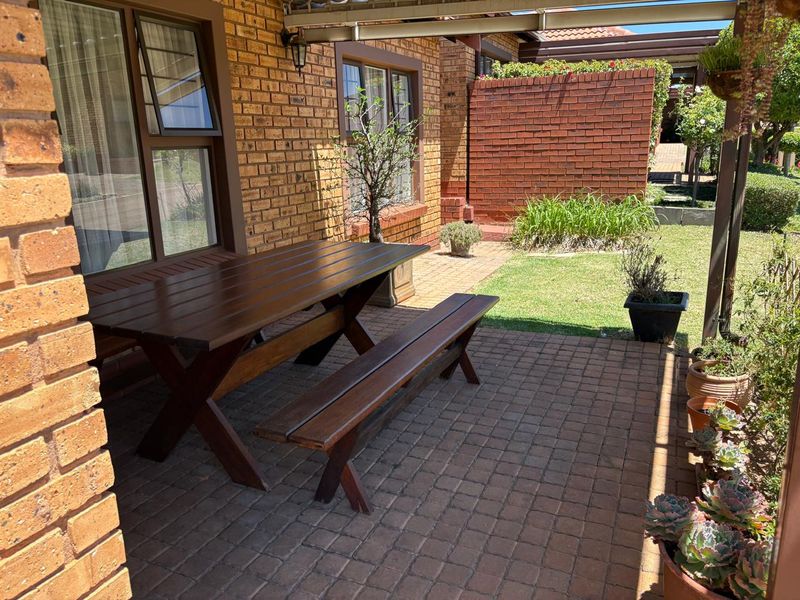 A covered patio area featuring brick paving and face brick walls, providing a pleasant outdoor space for relaxation.