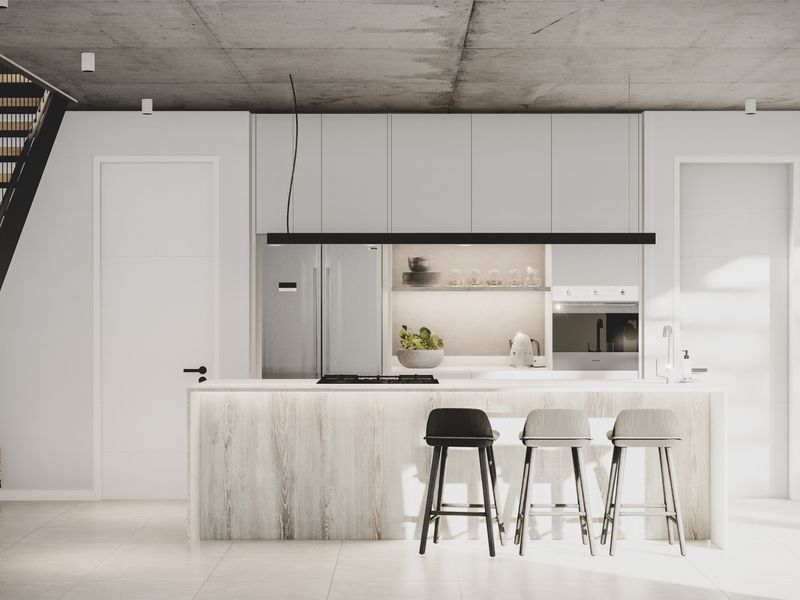 Modern open-plan kitchen featuring sleek cabinetry, a central island with breakfast bar, and an exposed concrete ceiling, seamlessly integrated with a contemporary staircase.