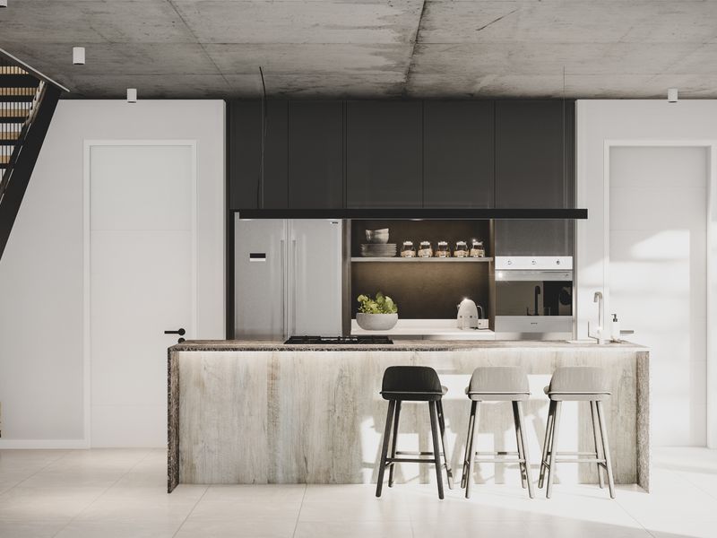 Modern open-plan kitchen featuring a stone-clad island, integrated appliances, sleek dark cabinetry, and an exposed concrete ceiling, adjacent to a contemporary staircase.