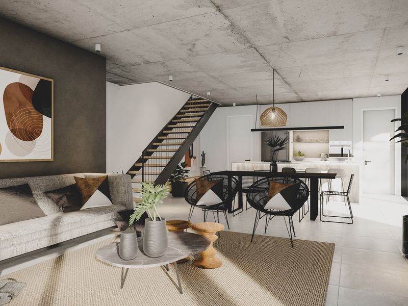 Modern open-plan living area featuring an exposed concrete ceiling, sleek kitchen with island, and a contemporary staircase in a well-designed, high-quality interior space.