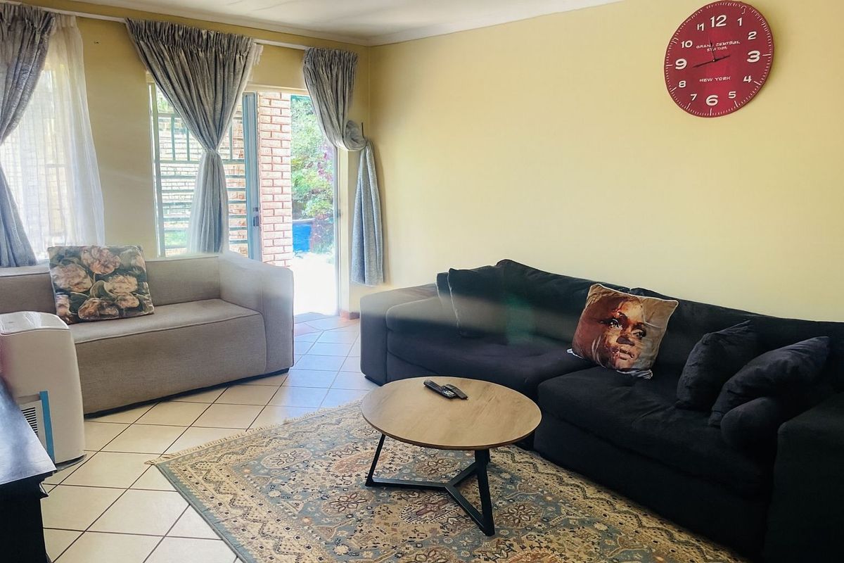 A comfortable living room featuring tiled flooring and a sliding glass door providing direct access to the outdoor patio area.