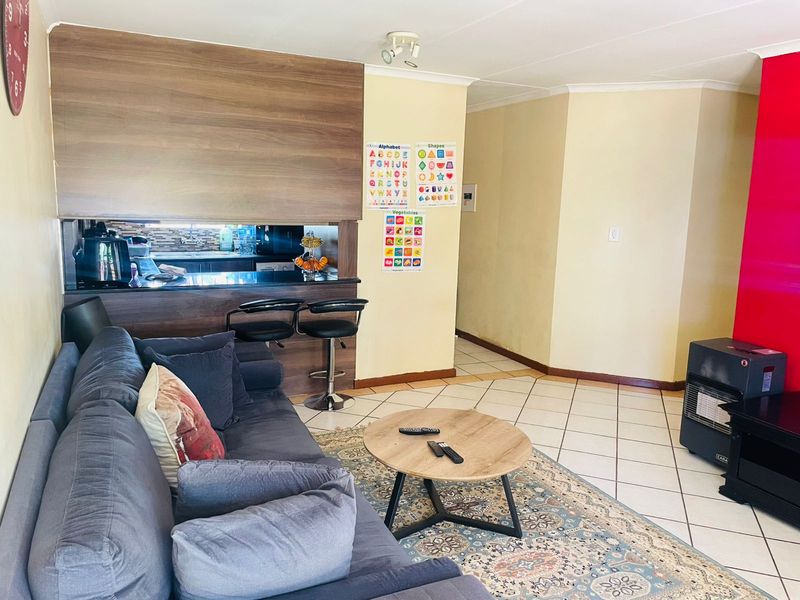 Open plan living area featuring a breakfast bar counter, tiled flooring, and a dedicated space for a gas heater.