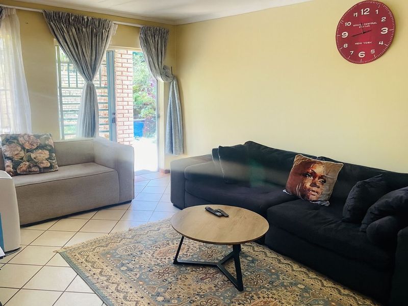 A comfortable living room featuring tiled flooring and a sliding glass door providing direct access to the outdoor patio area.