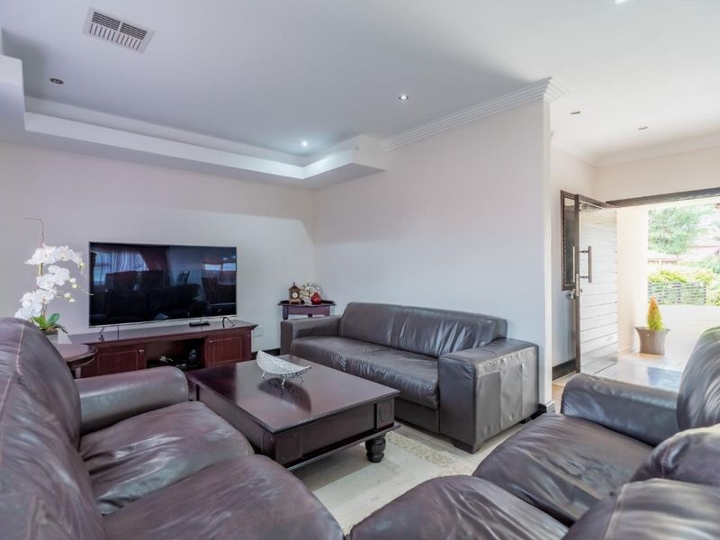 A well-maintained living room featuring a recessed ceiling with downlights and air conditioning, providing a comfortable and functional space.