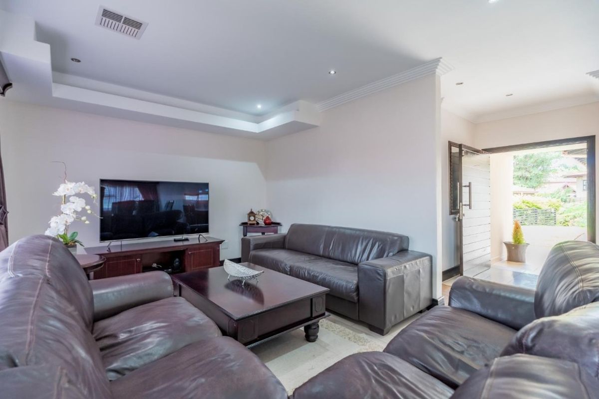 A well-maintained living room featuring a recessed ceiling with downlights and air conditioning, providing a comfortable and functional space.