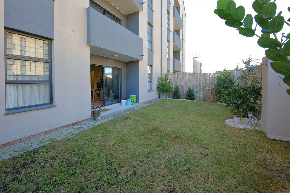 Ground floor apartment featuring a private garden with a paved walkway and direct access to the living area via sliding glass doors.