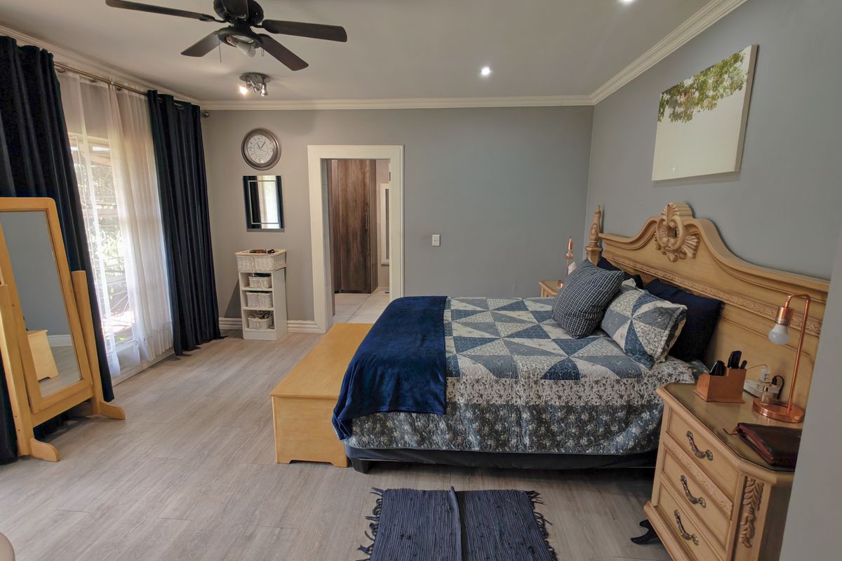 Spacious bedroom featuring light-toned wood-look flooring, recessed ceiling lighting, a ceiling fan, and direct access to an adjoining room.