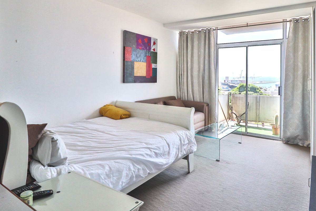 A bedroom featuring neutral carpeting and large sliding glass doors that provide access to a private balcony with exterior views.