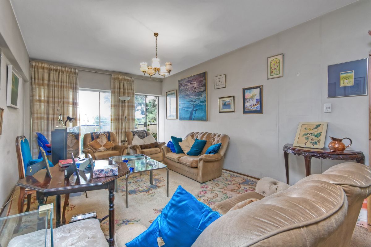 A spacious living room featuring large sliding glass doors that provide access to an outdoor balcony area, allowing for ample natural light.