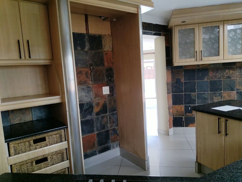Kitchen area featuring light wood cabinetry, granite countertops, and slate tile backsplash, with a dedicated space for a large appliance.