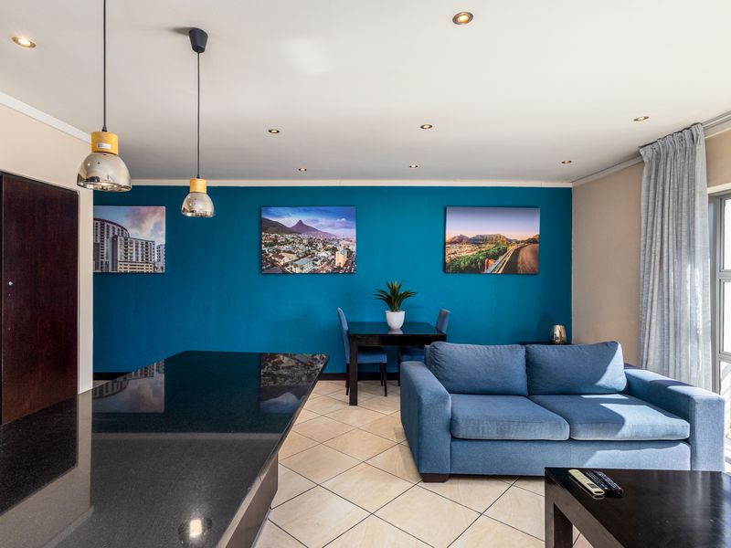 Open-plan living and dining area featuring a granite kitchen island, tiled flooring, and large sliding glass doors leading to an outdoor space.