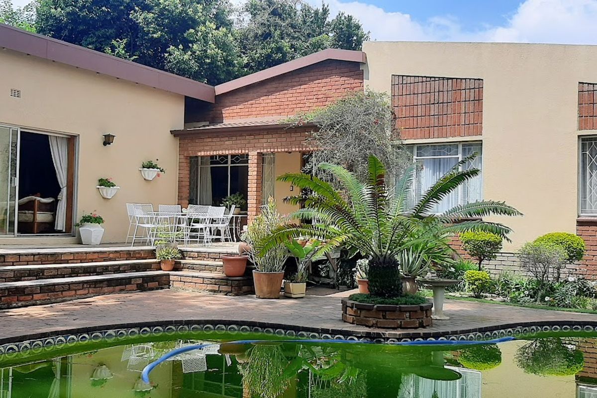 Rear view of the property featuring a paved patio area, swimming pool, and brick facade with sliding door access to the interior.