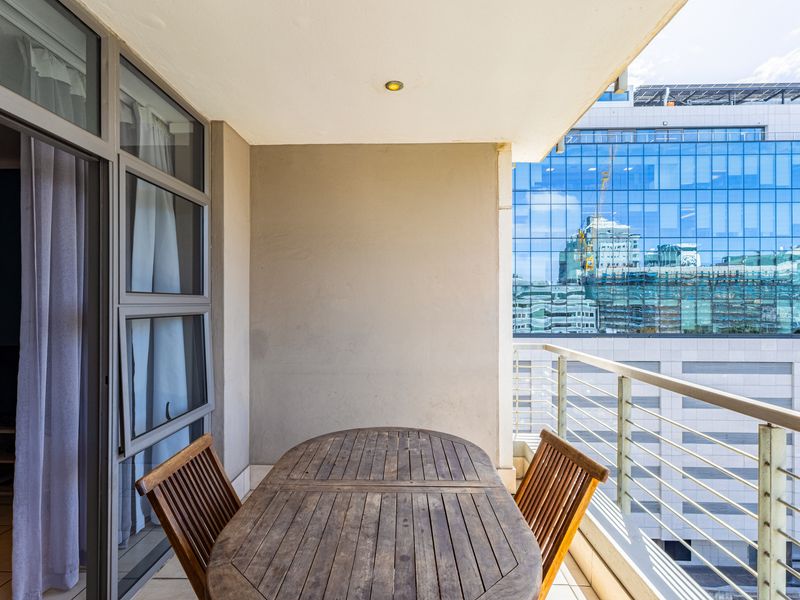 A covered balcony featuring tiled flooring, a metal balustrade, and direct access to the interior through a sliding glass door.