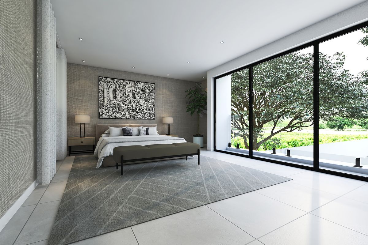 A modern, well-lit bedroom featuring large sliding glass doors that provide ample natural light and views of the outdoors.