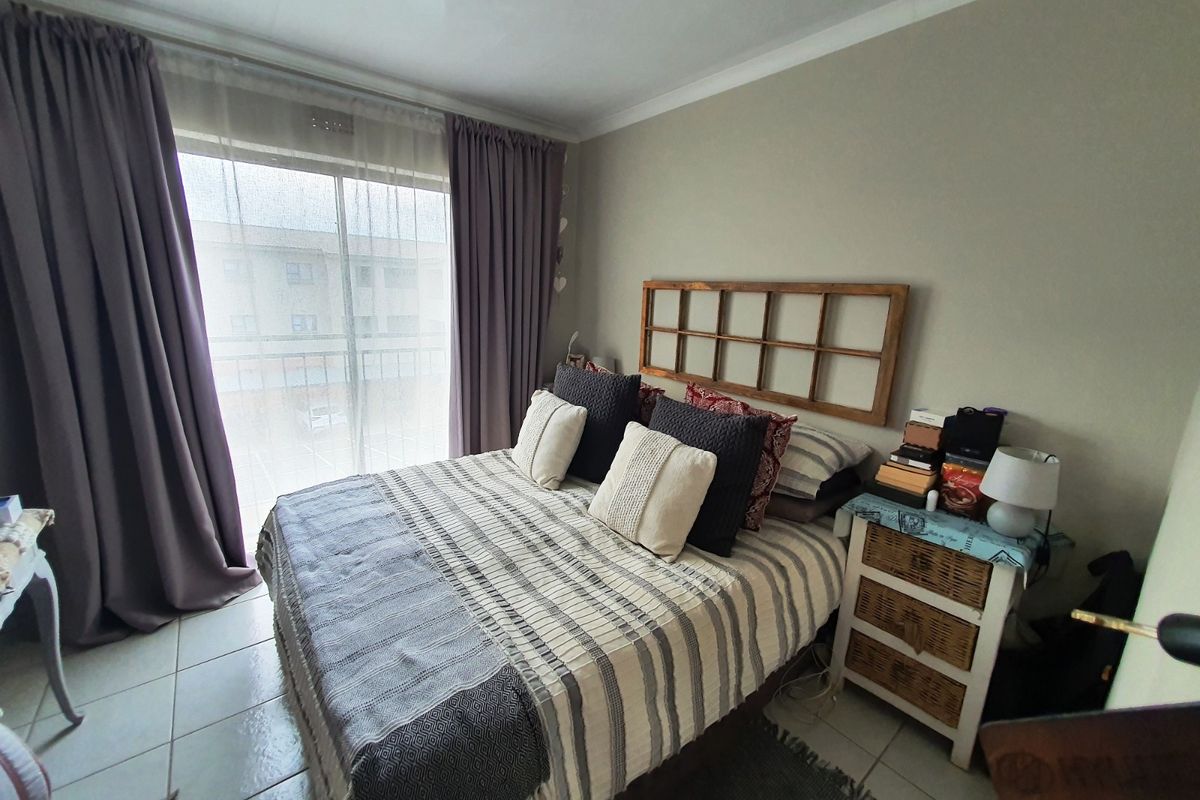 A bedroom featuring tiled flooring and a sliding glass door providing access to a balcony.