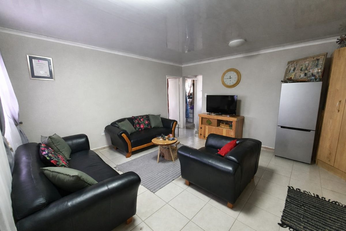 A functional living room featuring tiled flooring and a glossy ceiling finish, providing a neutral space for relaxation and daily living.