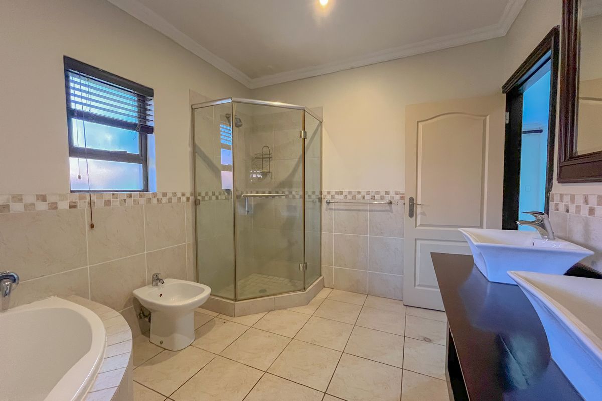 Spacious bathroom featuring a corner shower, built-in bathtub, bidet, and a double vanity with modern vessel sinks.