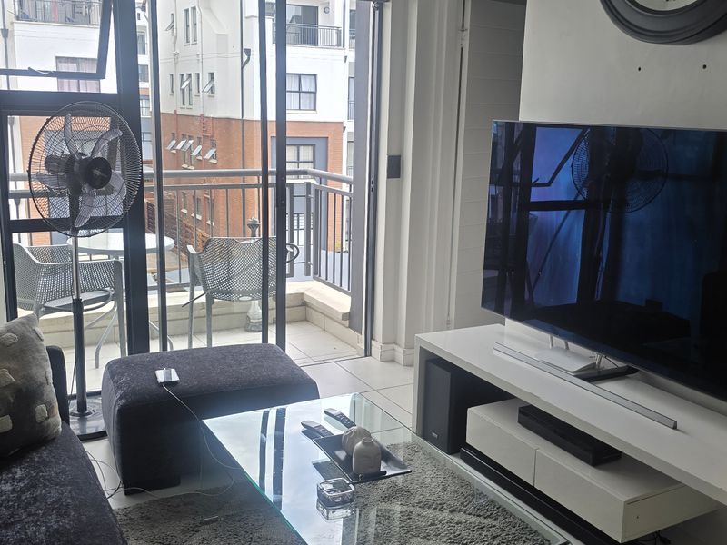 Open plan living area featuring tiled flooring and direct access to a private balcony through sliding glass doors.