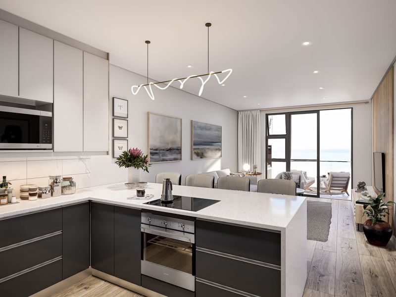 Modern open-plan kitchen and living area featuring sleek cabinetry, integrated appliances, stone countertops, and seamless access to a balcony with ocean views.
