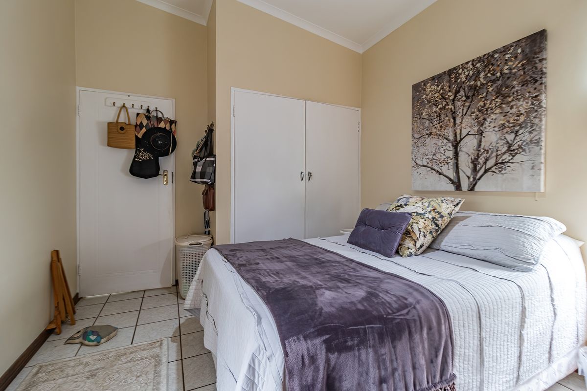 A bedroom featuring tiled flooring and built-in wardrobe storage.