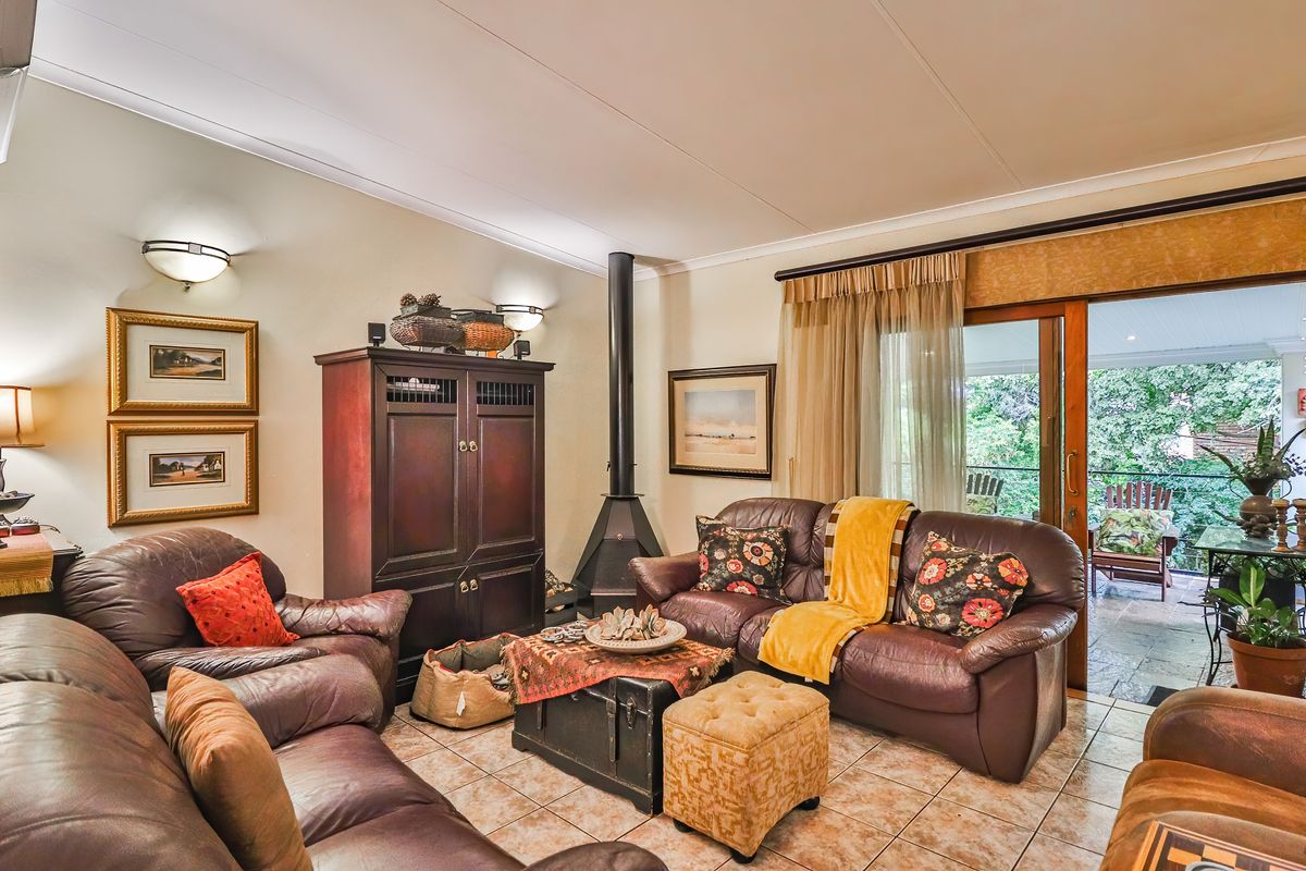 A cozy living room featuring a built-in fireplace, tiled flooring, and sliding glass doors that open onto a covered patio area.