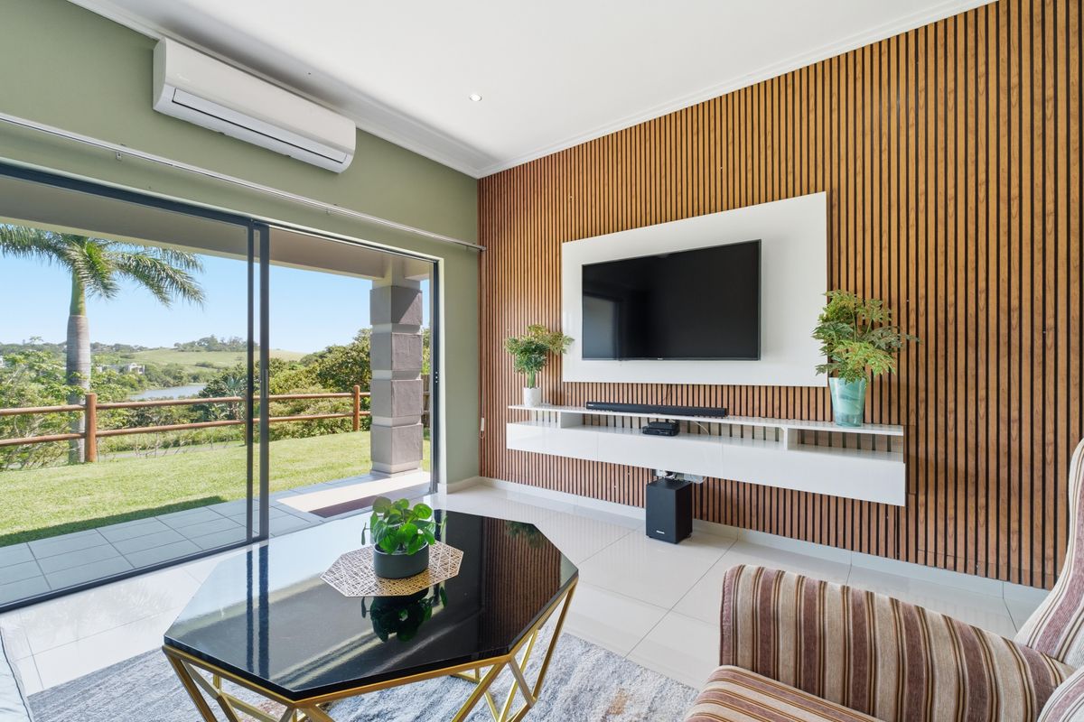 Modern living room featuring a timber slat feature wall, floating media console, split-system air conditioning, and large sliding glass doors opening to a patio.