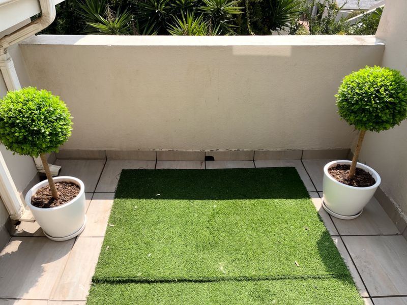 A compact balcony featuring tiled flooring and a solid perimeter wall, providing a private outdoor space.