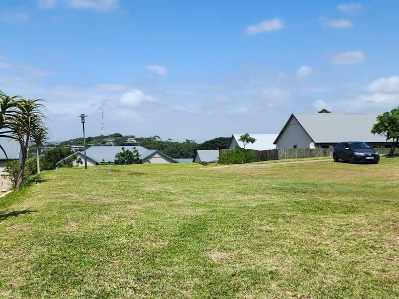 A spacious, well-maintained grassy plot situated within a residential estate, offering open views of the surrounding neighborhood and landscape.