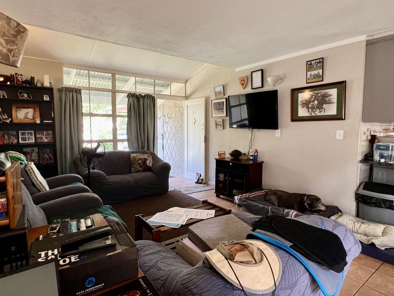 Open plan living area featuring tiled flooring, integrated kitchen cabinetry, and direct access to an outdoor patio area.