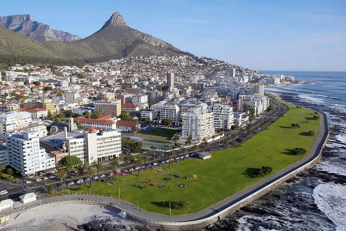 An aerial view of the coastal urban landscape, showcasing the proximity to the ocean, public green spaces, and the iconic mountain backdrop.