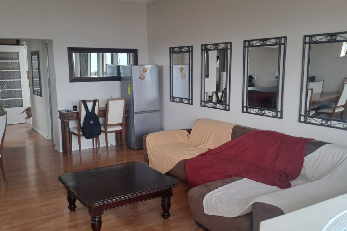 A spacious living area featuring laminate wood flooring and neutral walls, providing a versatile layout for comfortable daily living.