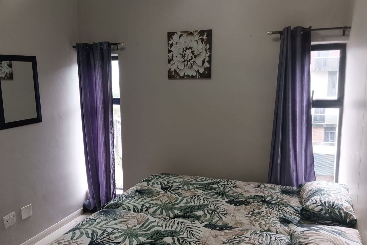 A bedroom featuring two windows with curtain rods and tiled flooring.
