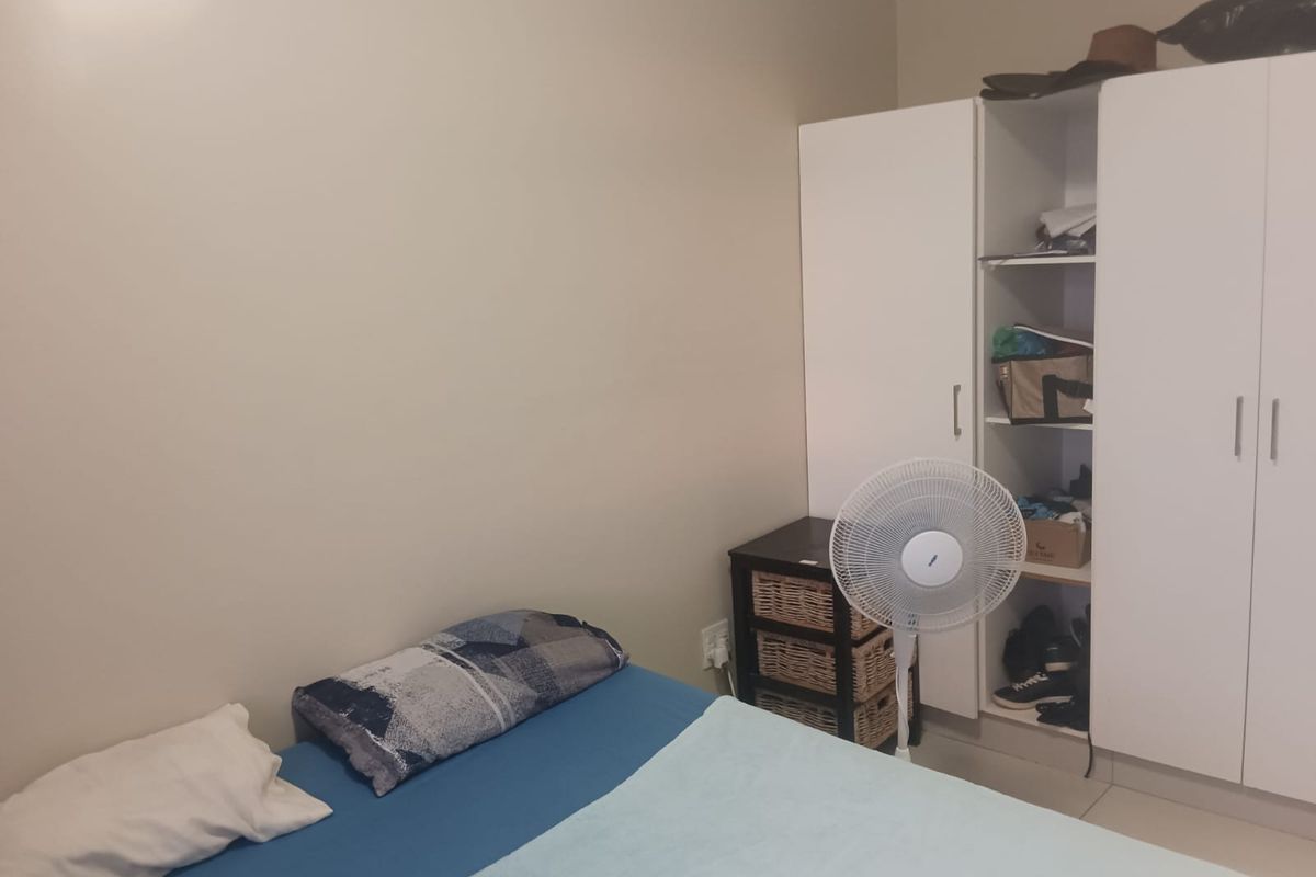 A bedroom featuring built-in white cabinetry and tiled flooring.