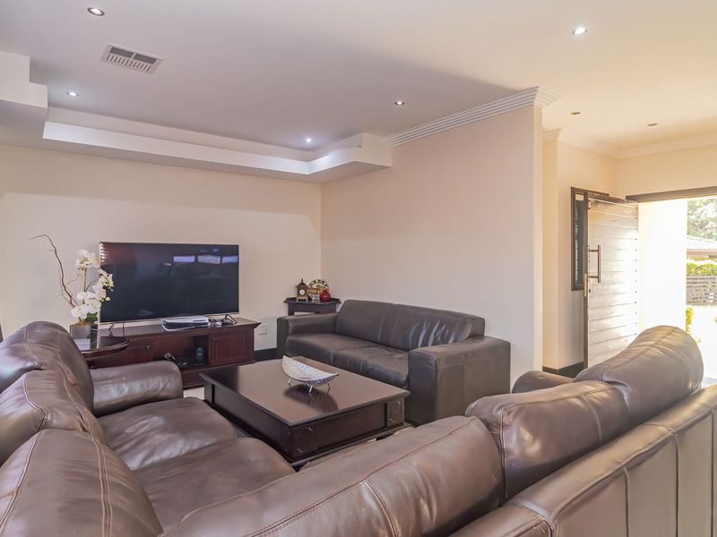 A spacious living room featuring a tray ceiling with recessed lighting and a direct entrance to the exterior.
